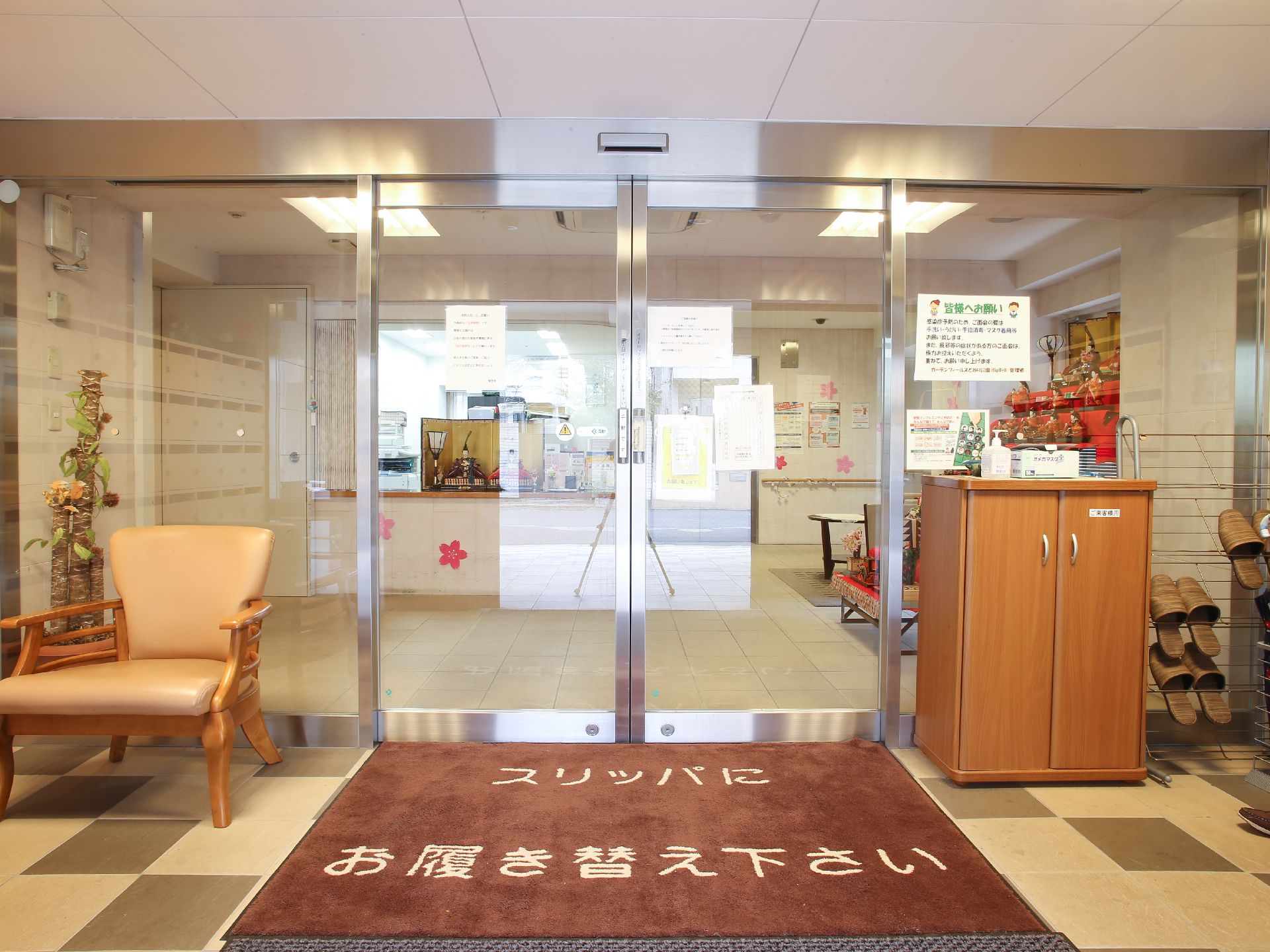 玄関を入ると右にスリッパが置いてある。正面はガラスの自動ドアになっていて四面がガラスになっていて明るい。