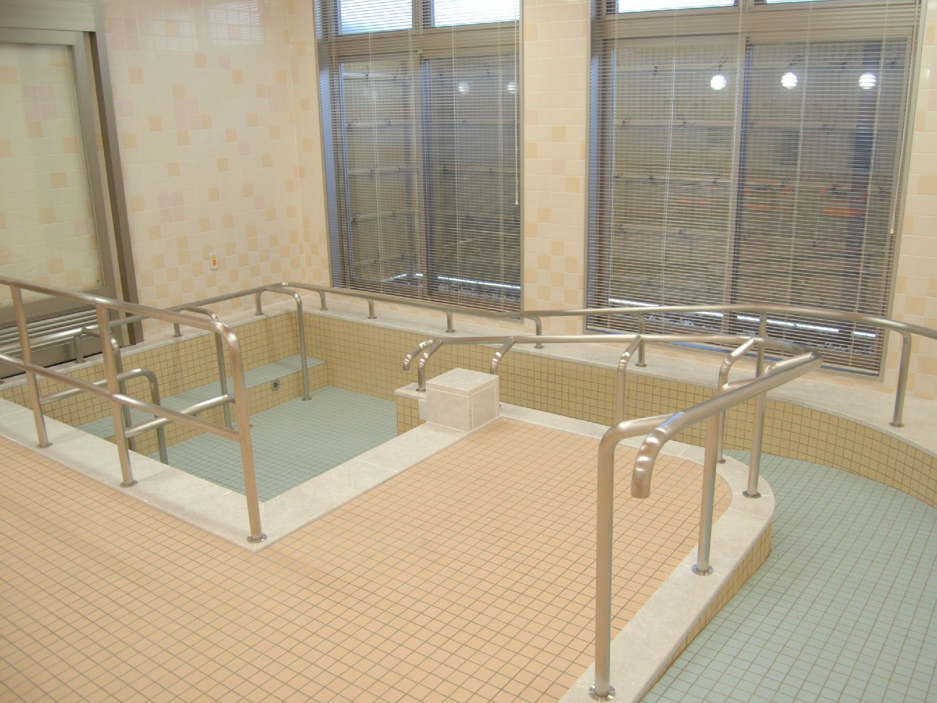 浴槽の周囲には、手すりが設置されている。浴槽へはスロープ続きになっている。手すりに掴まって、体勢を安定させて湯に浸かることができる。