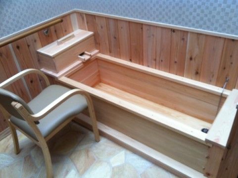 木で作られた浴槽が設置されている。吐水口が木箱で囲われている。浴槽近くには椅子があり、壁には手すりが設けられている。