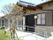 大きく張り出した瓦屋根の軒先が特徴的な、木造平屋建ての建物。玄関までの長いスロープには、両脇に手すりが設けられている。
