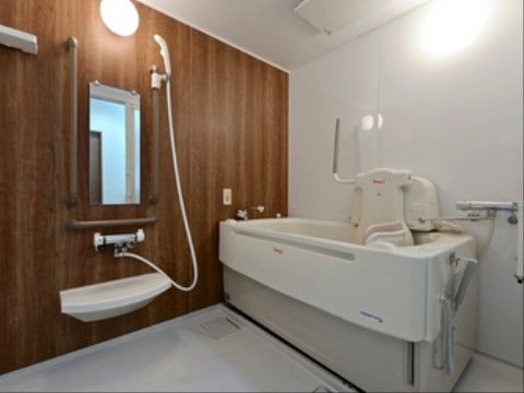 浴室には白い壁の面積が大きいが、１面のみ木目調の柄が入った素材を用いている。そのため、落ち着いた印象の室内に仕上がっている。