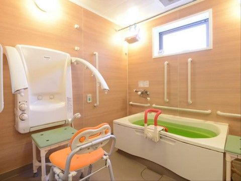 壁に手すりの付いた個浴。シャワーチェアーが置かれている。