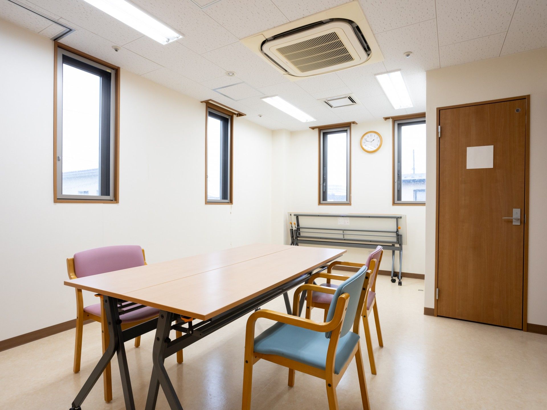薬を飲む高齢女性に水を差し出す女性スタッフ