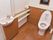 洋式のトイレが1つ設置してある。便器ブラシが横においてある。トイレットペーパー、手洗い場がついている。