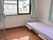 アルミ製のラックとベッドが部屋に設置してある。窓は2方向にあるため、部屋全体が明るい。窓には緑のカーテンがしてある。