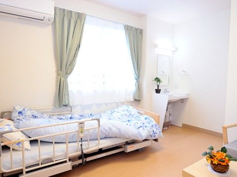 居室にはエアコンと独立洗面台が備わっている。窓際にベッドを置いて、通路を残してデスクなどの家具を置くことができる広さである。