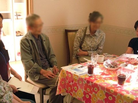 テーブルを囲んで、飲み物や会話を楽しんでいる入居者様