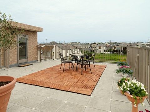 見晴らしの良い屋上テラス。ウッドパネルやガーデンテーブル、カップ型の植木鉢が上品な雰囲気を感じさせる。