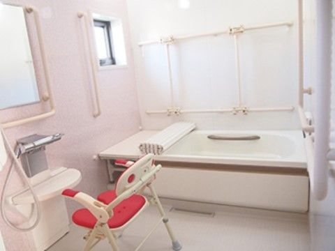 浴室にはゆったりしたサイズのバスタブとピンク色のシャワーチェアが設置されている。プライベートな空間でリラックスタイムを楽しめる。