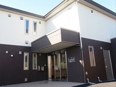 出入り口にはガラスの自動ドアが設置されている。ドアの横の壁には施設名が書かれたプレートが掲げられている。