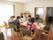 テーブルに向かって４人のスタッフが座り、話し合いを行っている。部屋には大きな窓があり、外光が差し込んでいる。