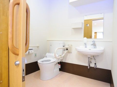 トイレは引き戸によって区切られており、温水洗浄便座の周囲には手すりと緊急呼出ボタンが設置されている。壁には洗面設備が設けられている。