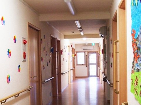 廊下の幅は十分に広く、安全に通行することができる。壁には手すりが設けられ、手作りの作品が飾られている。