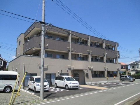 ２階建てで、壁はベージュと茶系の２色が使われており、シックで集合住宅のような外観である。建物前には細い道路があり、周辺は住宅地になっている。