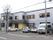 直線的な２階建ての建物で、１階の前が駐車場になっている。外壁はグレー系とベージュで、窓も多くて明るくお洒落な外観である。