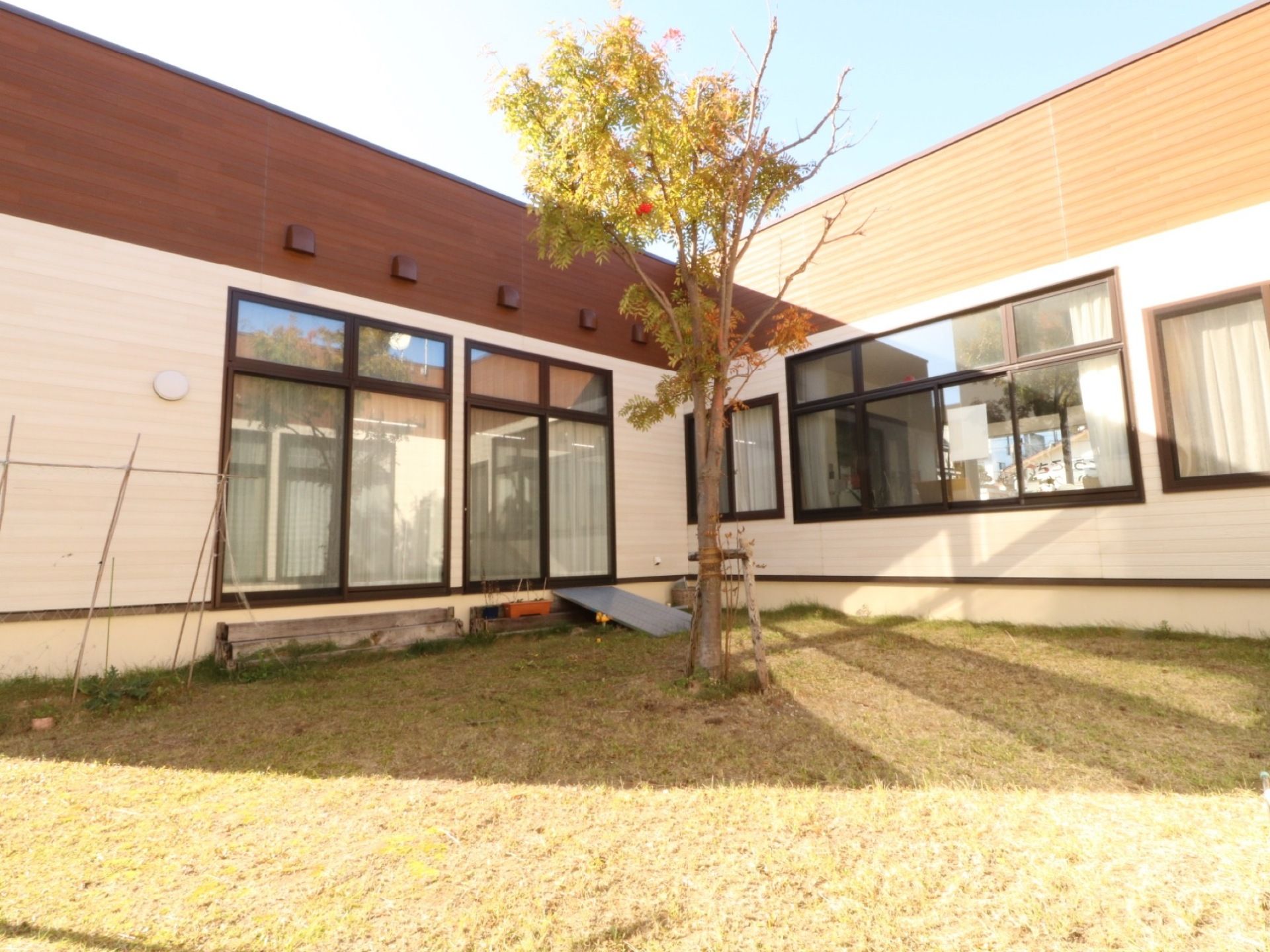 建物の間には芝生敷きの中庭が設置されている。板のスロープを設置して、車椅子をご利用の方も中庭を散策できるようになっている。