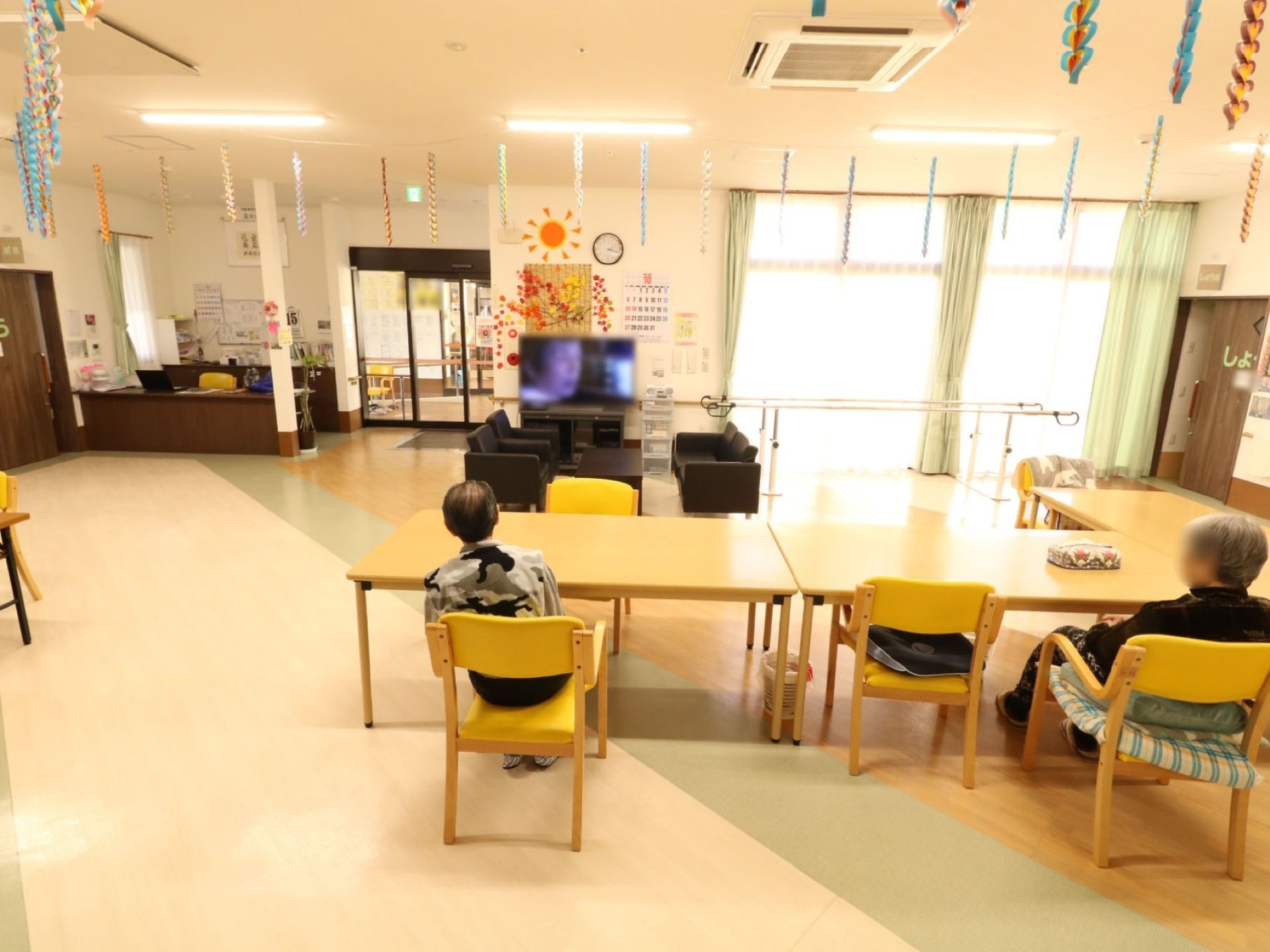 食堂の明るい窓際には、平行棒が設置されている。広いスペースの中で、気軽に機能訓練も行えるようにしている。