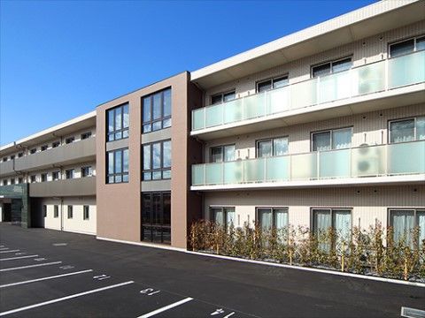 たくさんの駐車スペースを備えた、３階建ての施設の外観