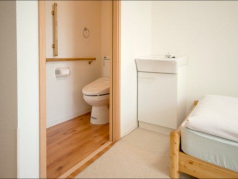 居室内にはトイレと洗面台、ベッドが置かれている。トイレの入り口はスライド式の扉であり、手すりが設置されている。