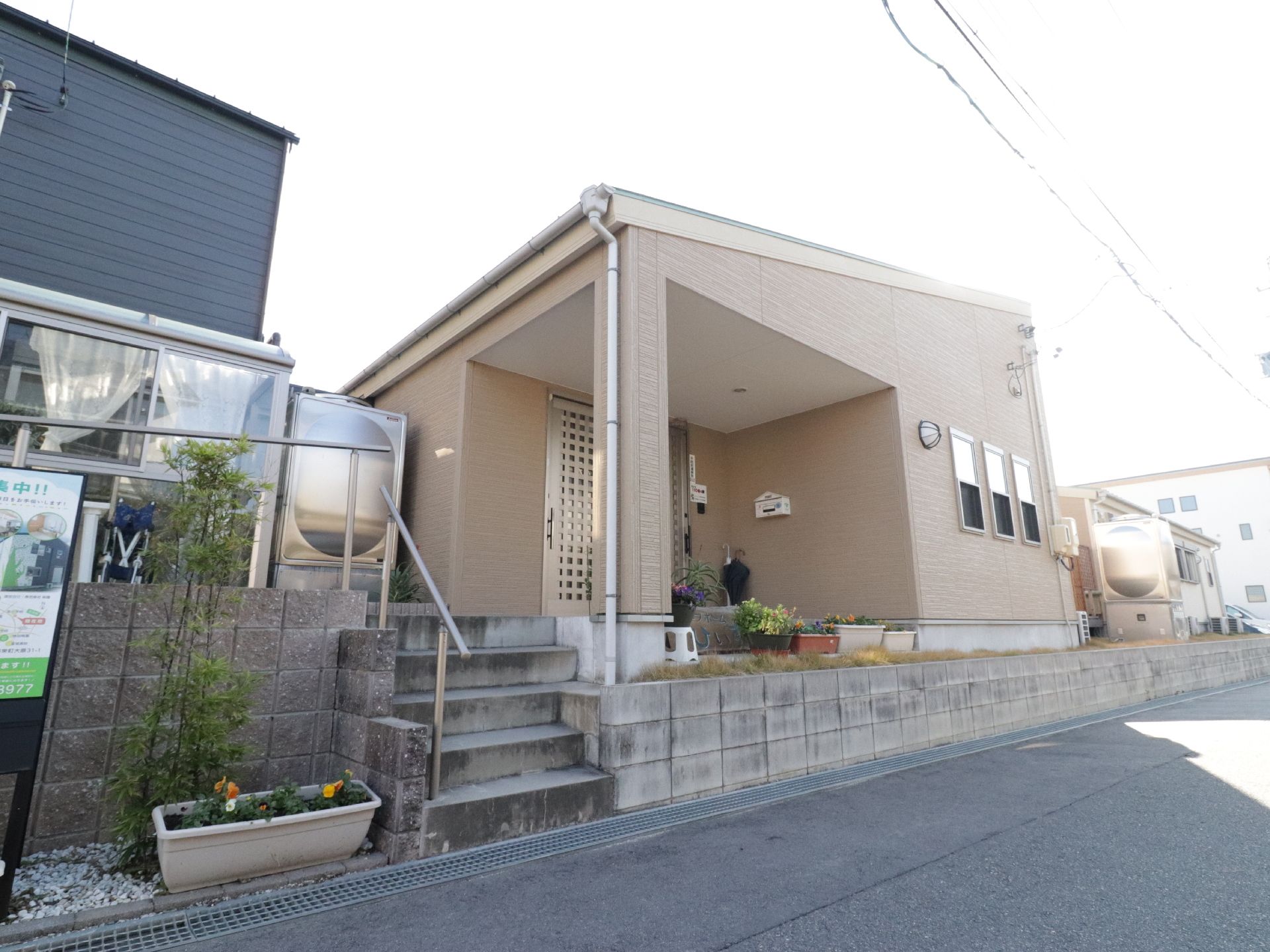家庭的な外観なので、入居者様は自宅のようにくつろいで過ごせる。玄関前には植物が育てられていてなごませてくれる。