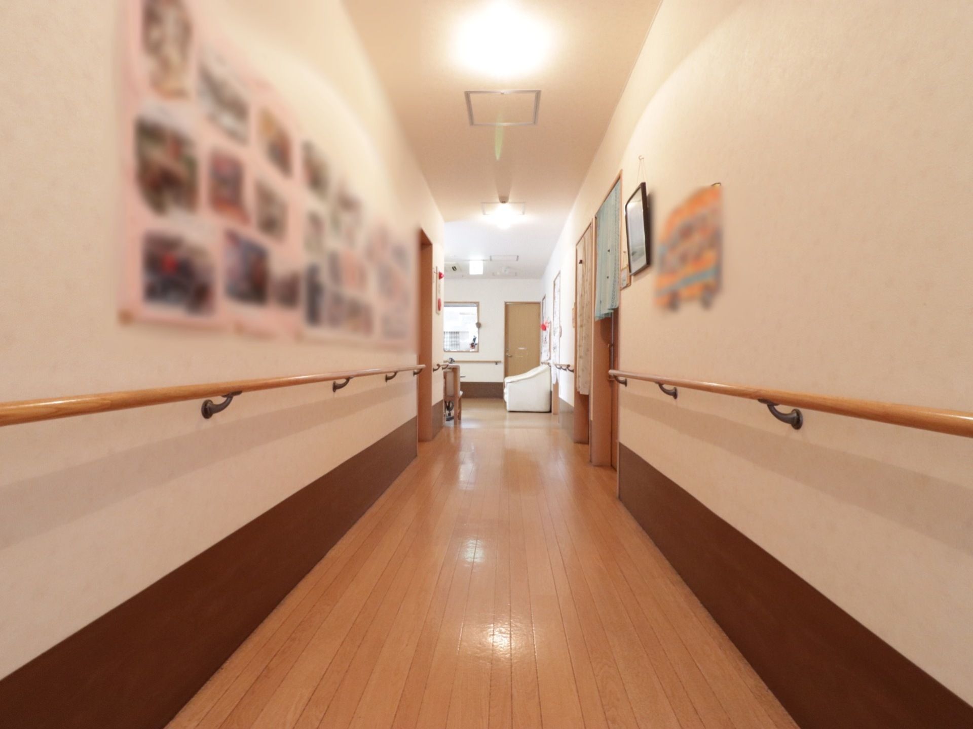 廊下は広々としており、両側の壁に手すりがあるので安全に移動することができる。壁が白く清潔感があるスペースである。