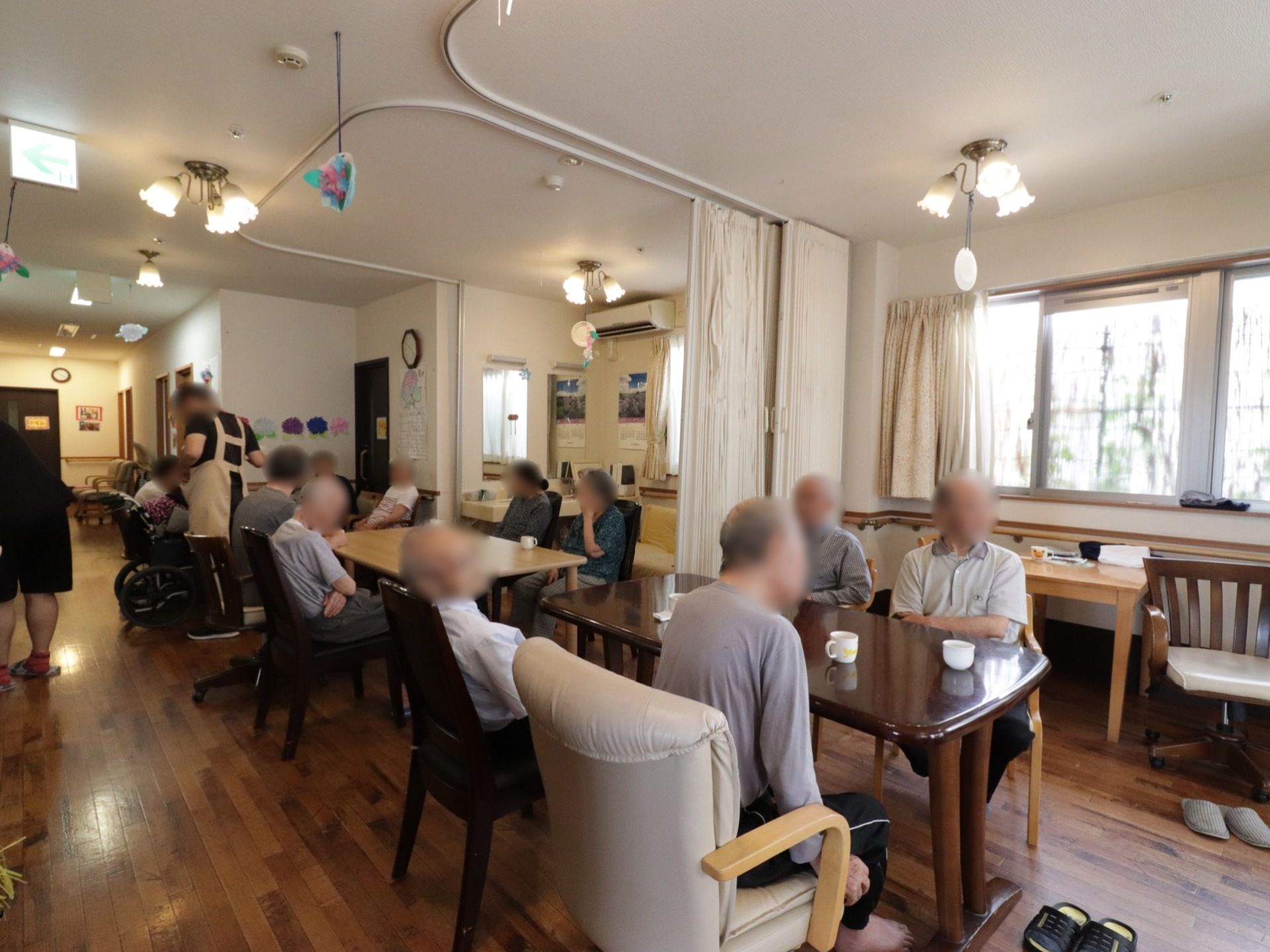 大きなテーブルとたくさんの椅子がある。多くの入居者様が集い、一休みできるお部屋となっている。交流会や会議にも適する。