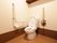 茶色と白でコーディネートされた、あたたかみのあるトイレである。L字型と可動式タイプの手すりが完備されている。