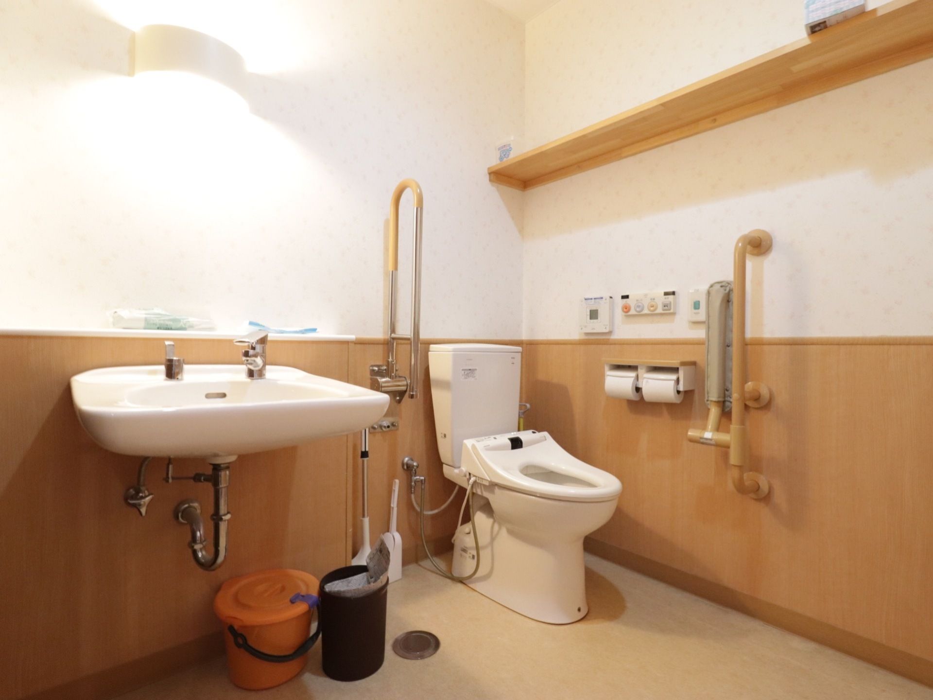 トイレには必要に応じて利用できる手すりが設置してある。広々とした個室内には、洗面台も用意されている。