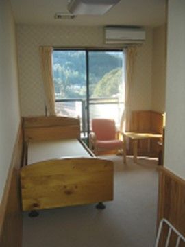 居室は壁に腰板を使用し、木製のベッドを配置するなど、木の温もりが感じられる雰囲気になっている。窓から緑豊かな景色を眺めることができる。