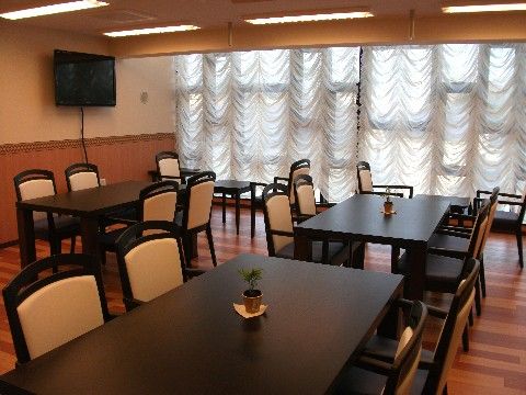 ダークブラウンの長方形のテーブルに、アイボリーベースの椅子がセットされたダイニングルーム