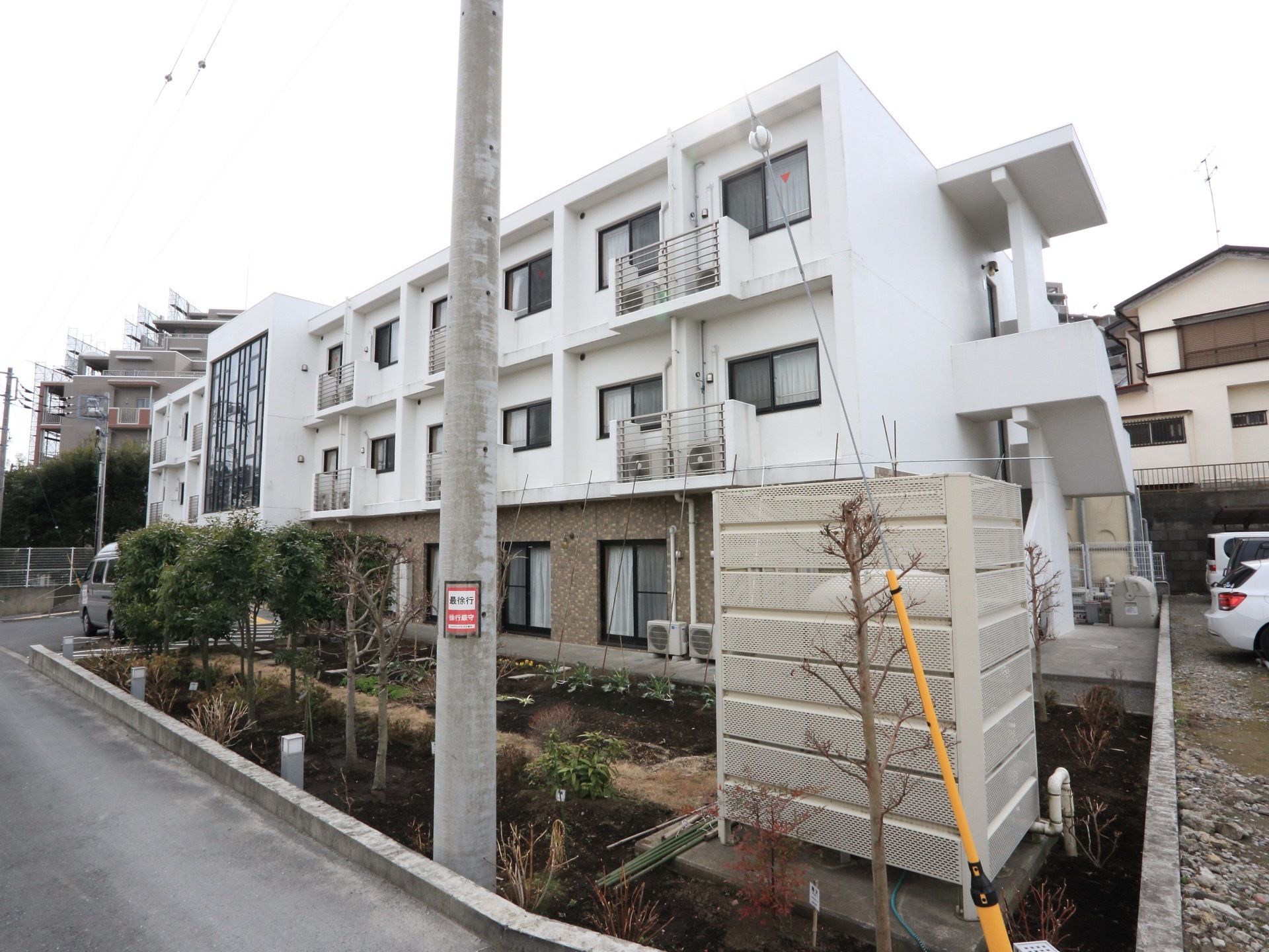 建物全体の外観を、斜め方向から写したものである。１階部分はブラウン系の色で、２階と３階は白でデザインされている。