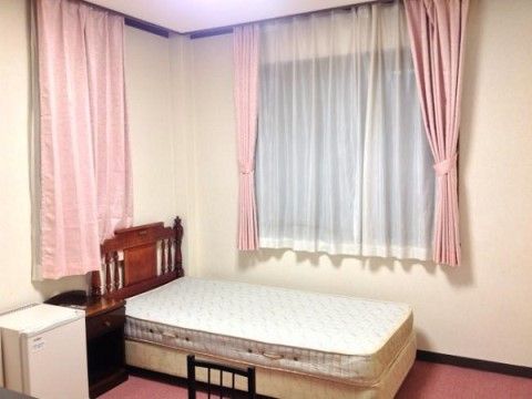 ピンク色のカーテンが取り付けられている窓がある部屋