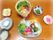 お肉や野菜、きのこ類が盛りつけられたお皿とすきやき鍋、白ご飯などが並んだ食事