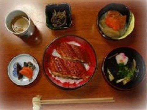 机の上に配膳され、大きなウナギの蒲焼きが2つのっているうな重定食