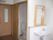 室内は白と木目のベージュで統一感のある空間になっている。入ってすぐに引き戸のトイレがあり、その奥には洗面台がある。
