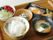 木製のトレーに一食分の食事が並べられている。ご飯と汁物の他に、野菜が使われた健康的なおかずが３品付いている。