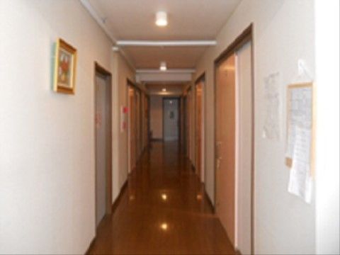 暖色の照明を使用しており、廊下を暖かな光で照らしている。壁には消火の警報ベルが付いており、赤いランプが付いている。