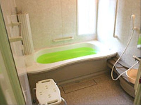 細長い窓が付いており、そこから太陽の光が差し込んでいる。湯船には黄緑色の入浴剤が入ったお湯が入っている。