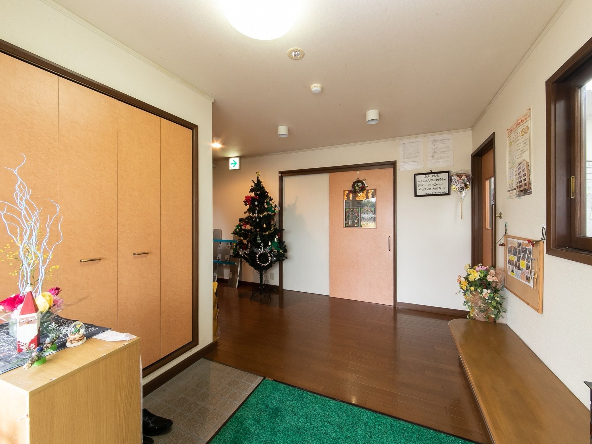 玄関と廊下は段差のないフラットな床となっており、マットが敷かれている。大きなクリスマスツリーが飾られている。