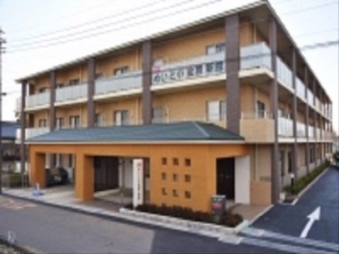 上階にベランダが設置された、オレンジ色の外壁の３階建ての施設