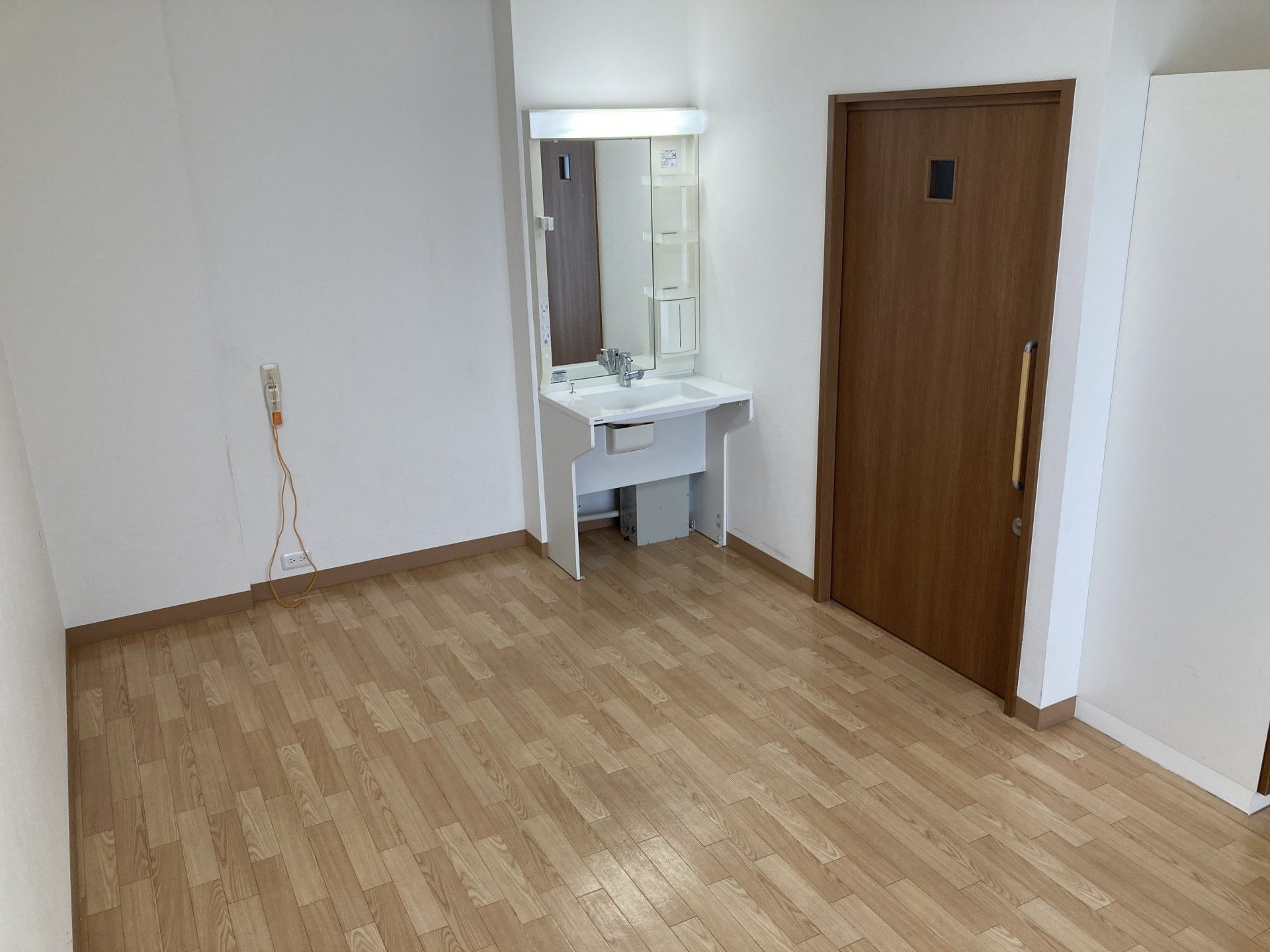 赤い車椅子に座っている高齢女性と笑顔で介助をする女性ヘルパー