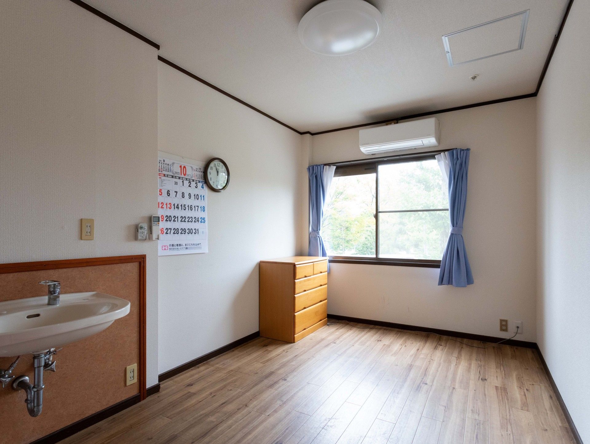 車椅子に乗って外出をする高齢女性と付き添う女性ヘルパー