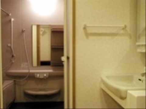 洗面台の奥に浴室がある。浴室への入り口が広く、出入りしやすくなっている。広い空間で、ゆったりおくつろぎいただける。