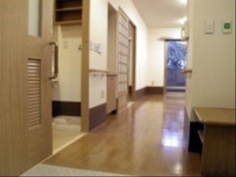 木の温もりを感じられる、落ち着いた雰囲気の廊下。手すりを左右に設け、幅が広い空間なので、すれ違いしやすくなっている。