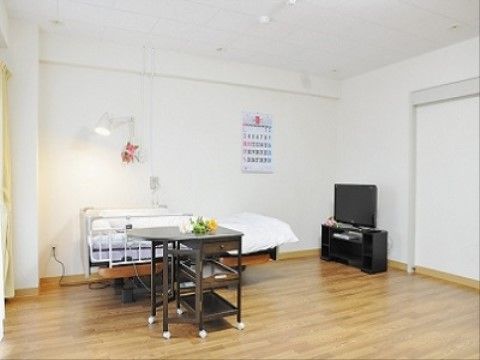 広々とした明るい居室。ベッドの横の壁には、ライトが設置されているので、ベッドの上でも手元を明るく照らすことができる。