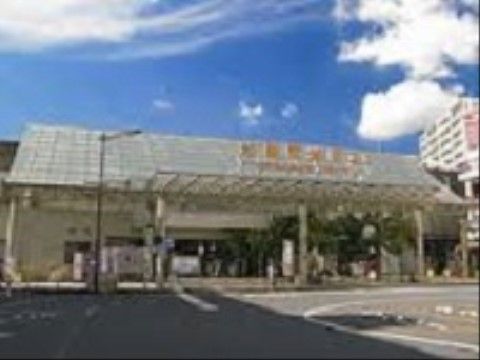 大きなひさしと、傾斜した屋根が印象的な最寄り駅の外観。駅前はバスやタクシーが行き交うロータリーになっている。