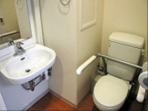 白を基調とした、清潔感のあるトイレ。トイレわきには手すりを設置しているので、自立した排泄がしやすい。