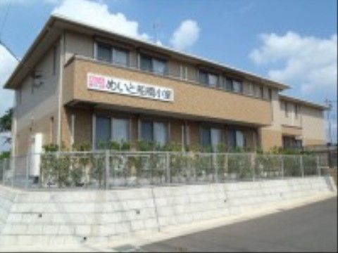 施設の外壁は１階がブラウン、２階はベージュと２色に分かれている。２階のベランダには施設名の書かれた白い看板が掲げられている。