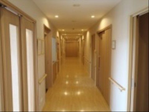 幅の広い廊下の両サイドの壁には手すりが設置されている。程よい明るさの照明が落ち着いた雰囲気をもたらしている。