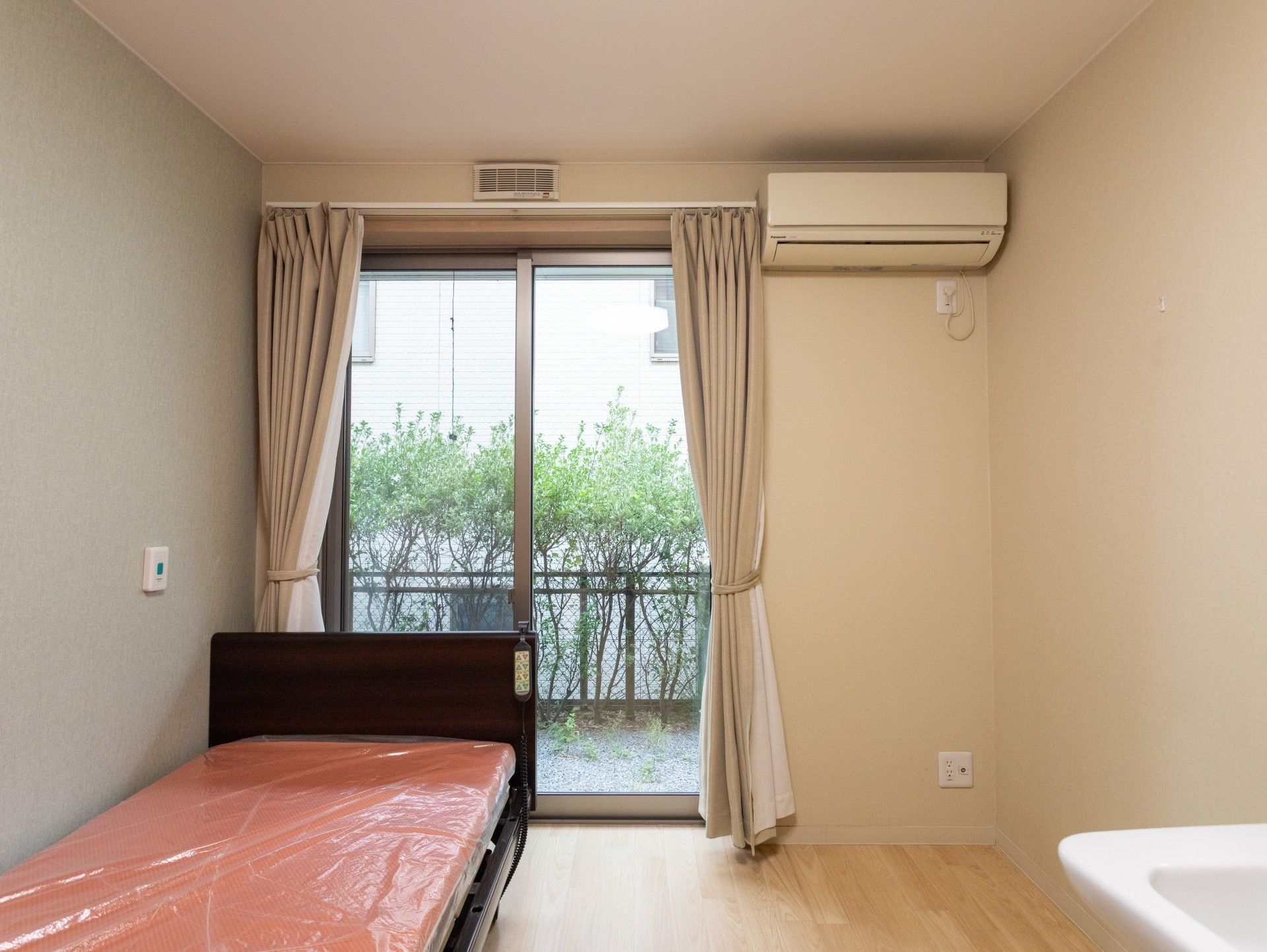 顔を見合わせる車椅子に座っている高齢女性と女性ヘルパー